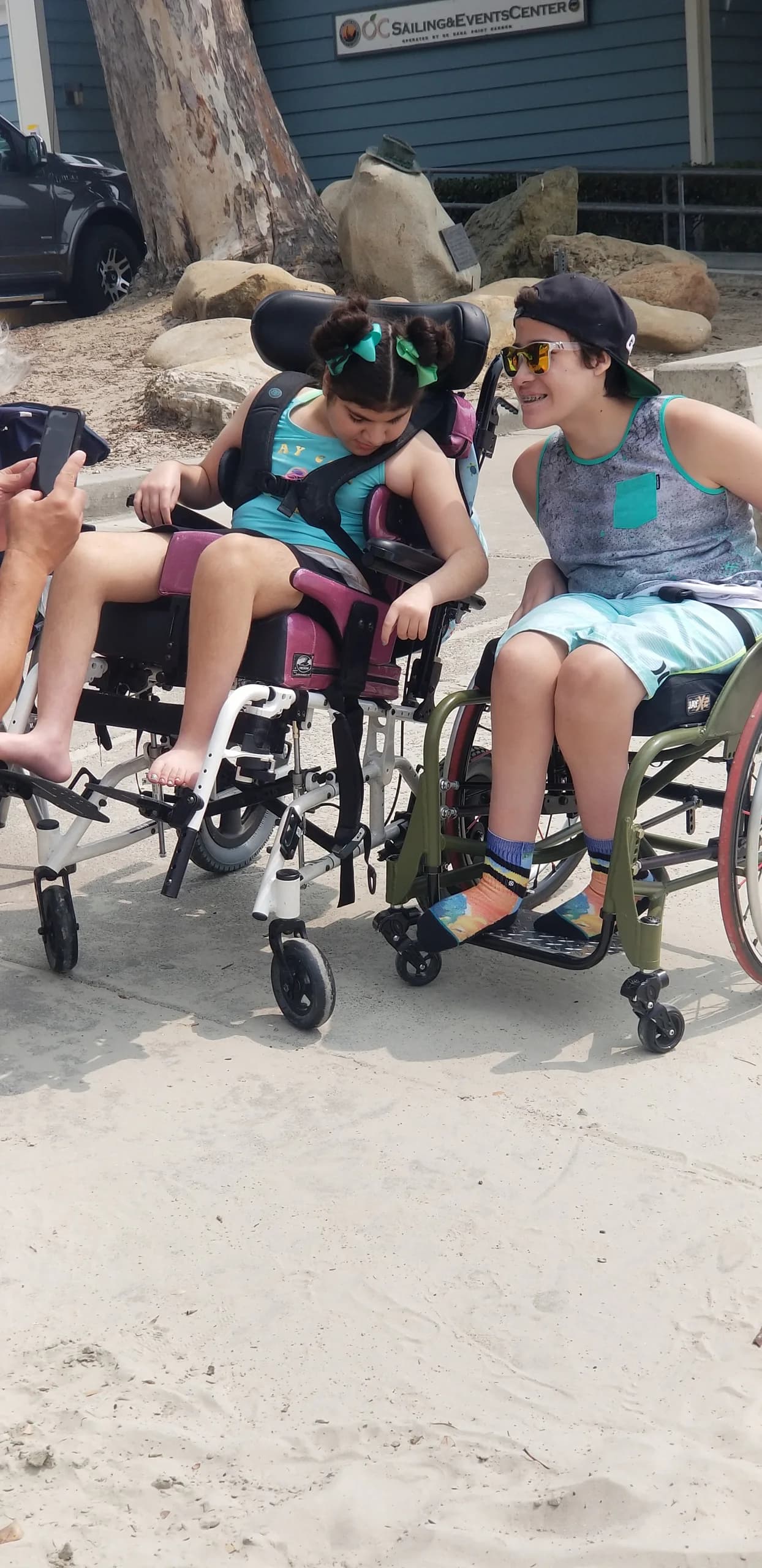 Two wheelchair users spending time together under an event canopy