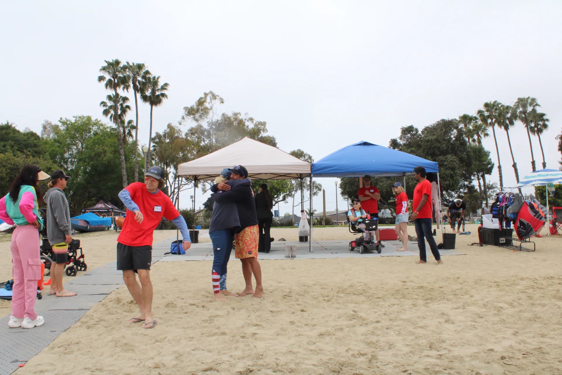 Community members gathering beneath AFF event tents near the water