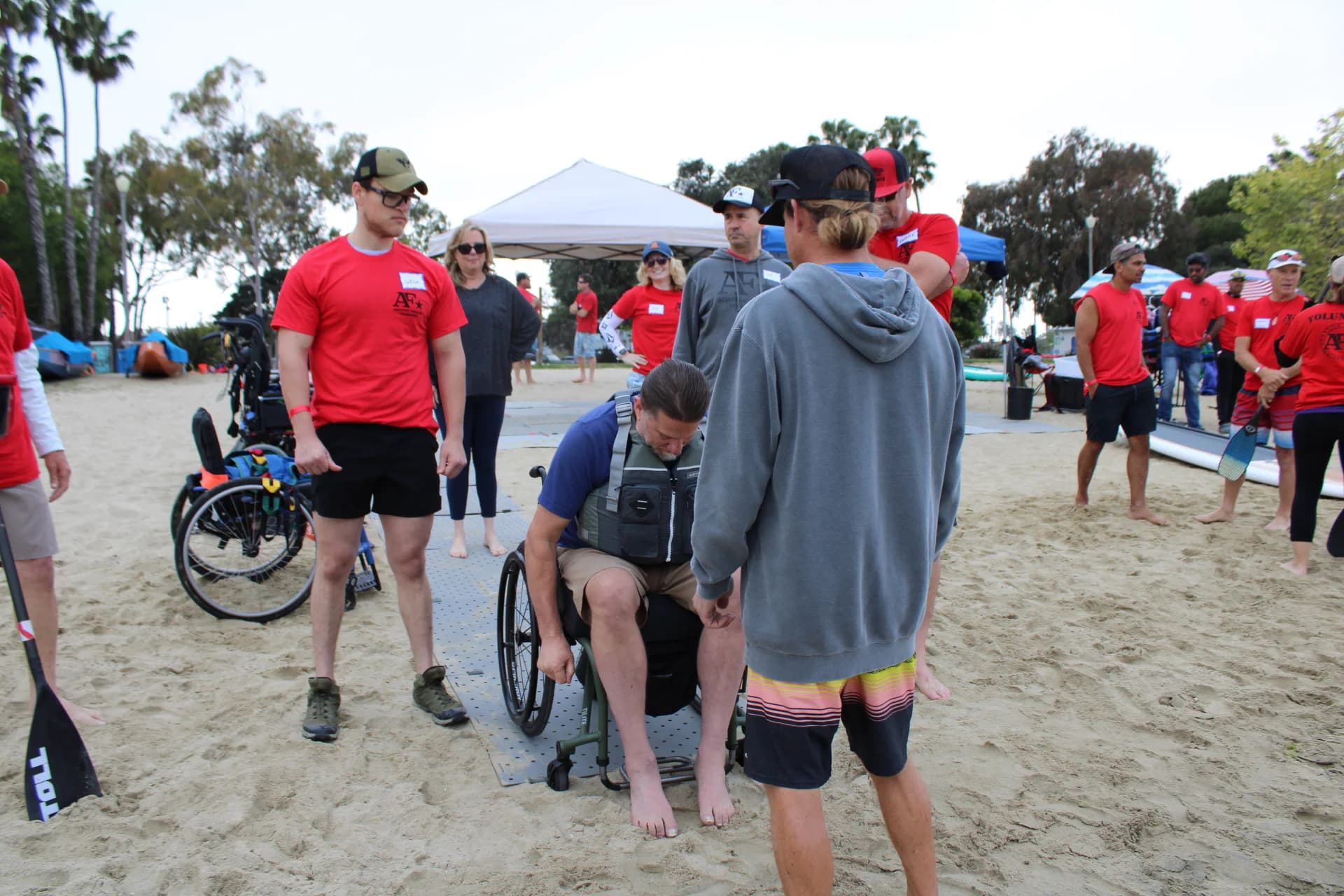 An AFF volunteer speaking with a wheelchair user at the shore