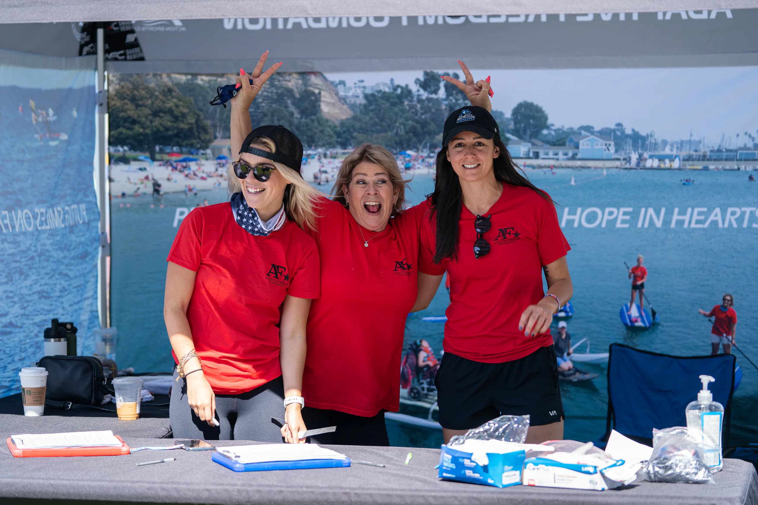 Three AFF volunteers welcoming the community at a check-in table