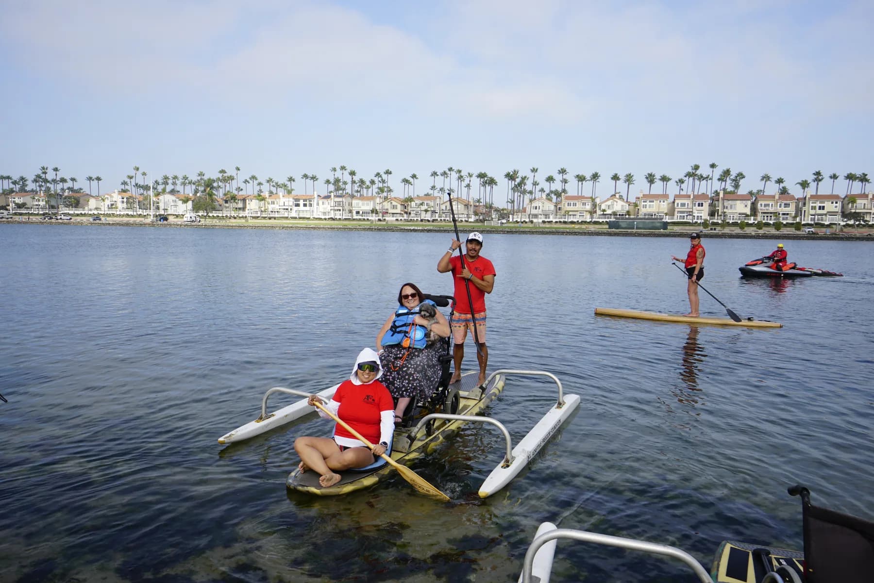 Two adaptive paddle teams moving together across Newport Beach water