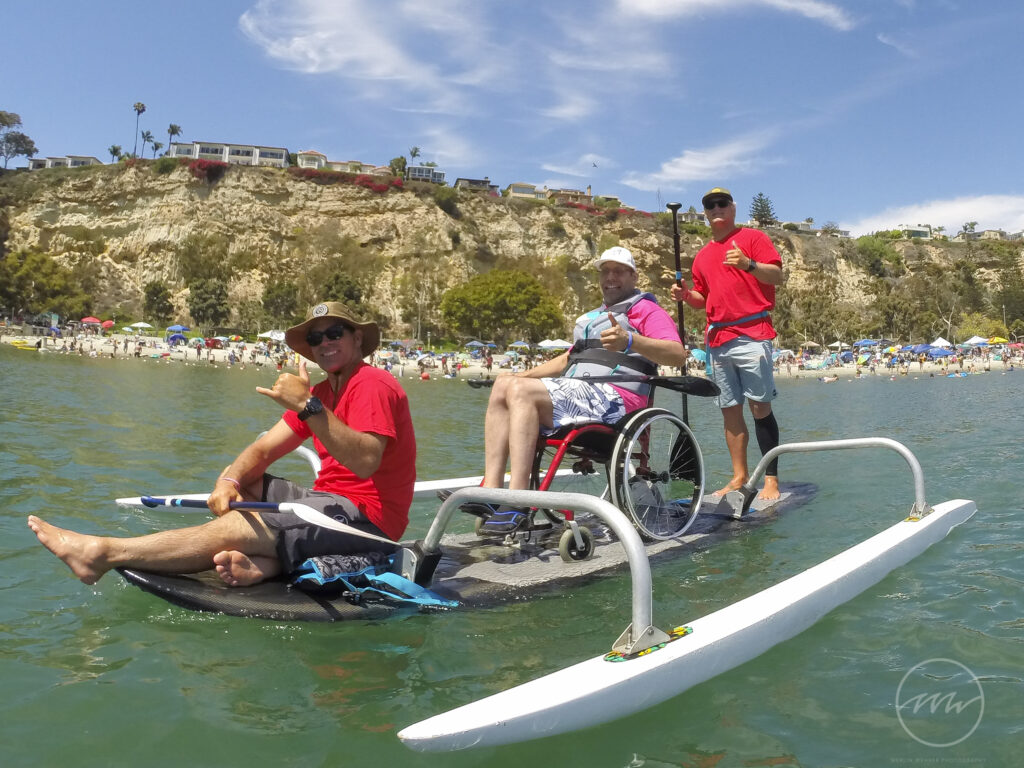 G2665265 WASUP Board with an adaptive paddler in a wheelchair and two volunteer paddlers